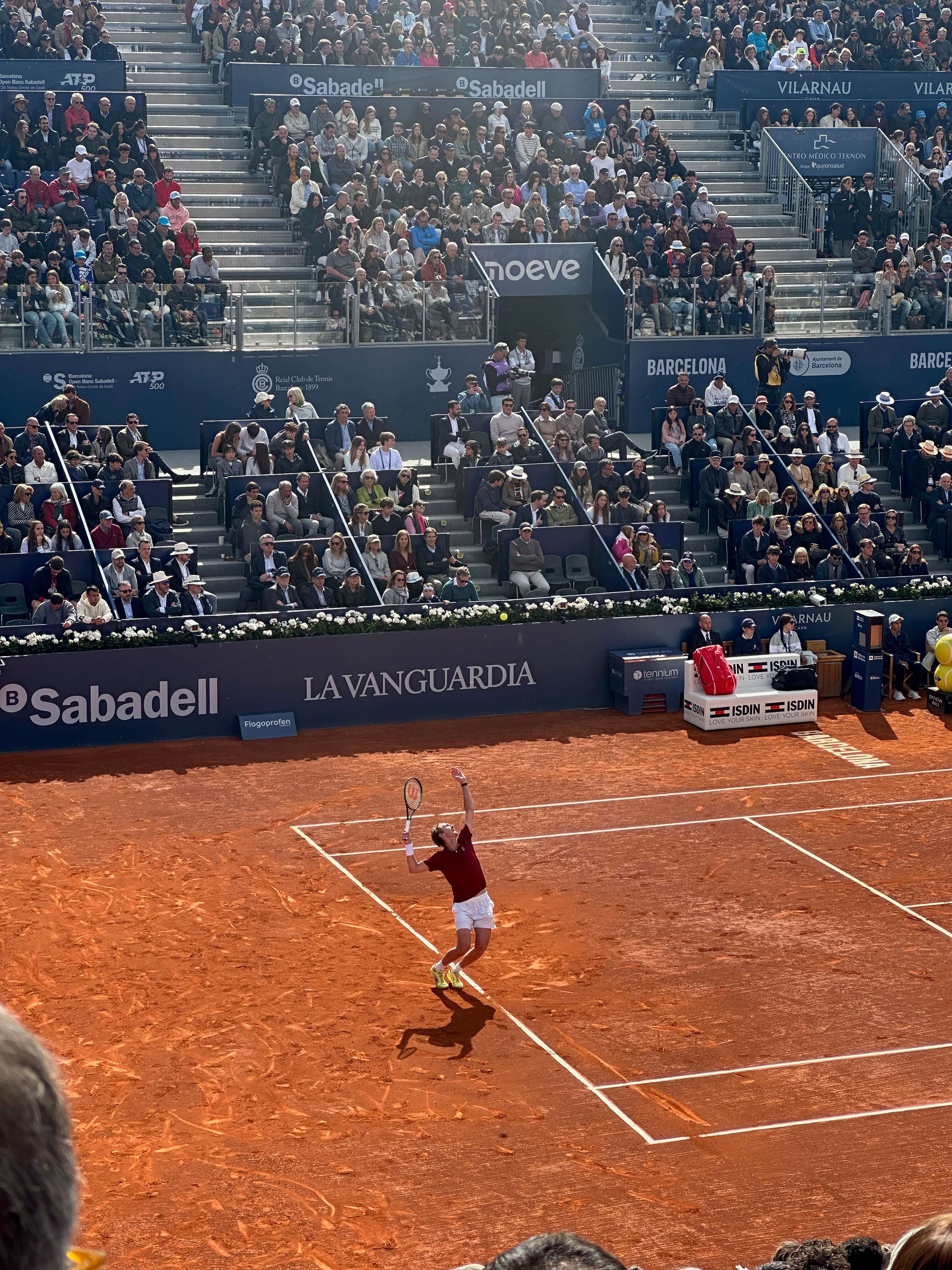Player serving on the clay courts at the Barcelona Open